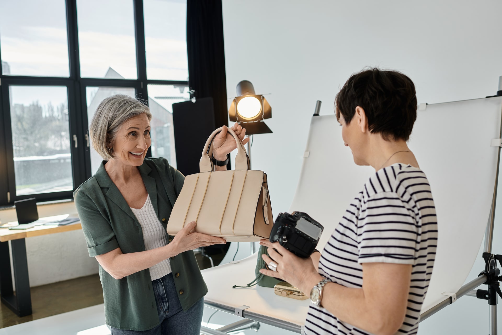 Personalized Promotional Products Edmonton 21 A middle-aged woman holding a purse and camera in a modern photo studio.
